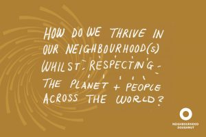A soft brown card with a spiral pattern and the words "How do we thrive in our neighbourhood(s) whilst respecting the plant + people across the world?" in white handwriting