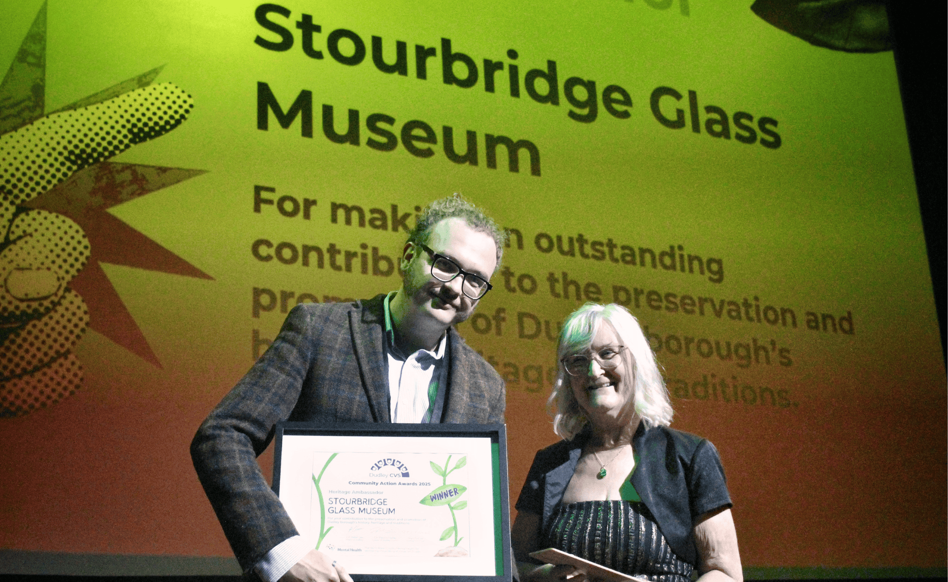 Two people holding an award at Dudley CVS AGM and Community Action Awards 2025.
